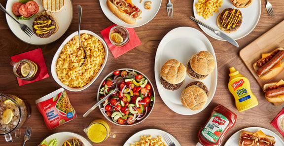 frenchs products on table among food like burgers and mac and cheese